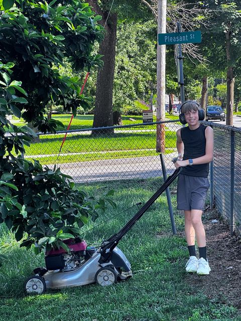 Stanley with his push mower under the Pleasant St street sign in Des Moines